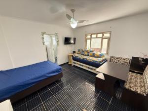 Un dormitorio con dos camas y una mesa y un sofá. en Pie en la arena de la playa Tupi, en Samaritá