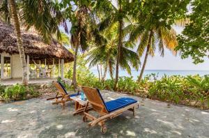 two lounge chairs and a table on a beach at Isla Amor in Cartagena de Indias