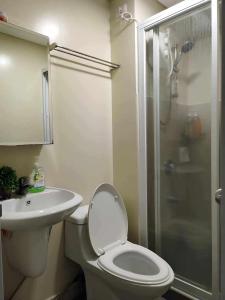 Un baño con inodoro, lavabo y ducha. en 2-BR Condo at the heart of the city, en Davao City