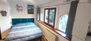 a small bedroom with a bed and two windows at Studio 24m2 cosy classé, lit Queen Size, Netflix, wifi, 400m centre, parking, boîte à clés, Gîtes La Tarine in Albertville