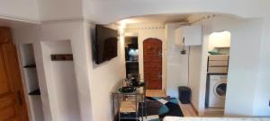 a room with a kitchen and a living room at Studio 24m2 cosy classé, lit Queen Size, Netflix, wifi, 400m centre, parking, boîte à clés, Gîtes La Tarine in Albertville