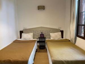 two beds in a small room with a table at MSC Sport Campus in Marrakesh