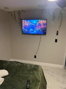 a flat screen tv on the wall of a bedroom at The Secret Garden Games Getaway in Orlando