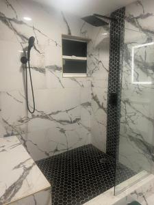 a shower in a bathroom with a black and white at The Secret Garden Games Getaway in Orlando +150 photos