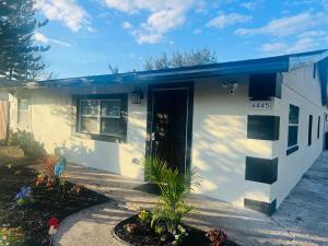 a small white house with a blue roof at The Secret Garden Games Getaway in Orlando