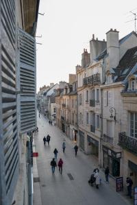 a group of people walking down a street with buildings at Dijon Hypercentre - Loge de la chouette in Dijon