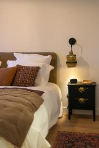 a bedroom with a bed and a side table with a lamp at Dijon Hypercentre - Loge de la chouette in Dijon