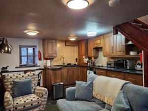 a living room with a couch and a kitchen at Causeway Cottage in Cartmel +3 photos