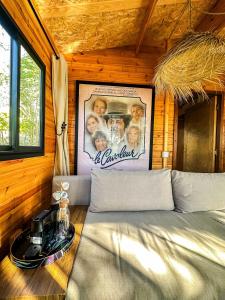 a bed in a room with a picture on the wall at Evergreen 1BR Wood Cabin with Bassin & Terrace in Al Azifat