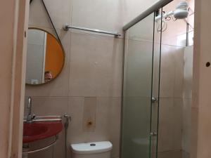 a bathroom with a shower and a toilet and a mirror at Kitnet 02 em frente a UNAMA in Belém +3 photos