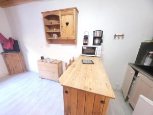 a kitchen with a wooden counter top with a microwave at 2 pièces cosy la Foux d 'Allos centre station 30 m carrés in Allos