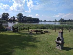 a park with a picnic table and a lake at Lawendowy domek in Iława +5 photos
