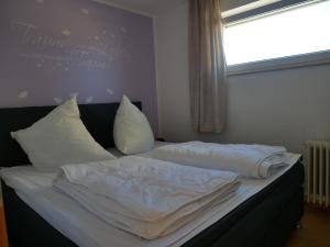 a bed with white sheets and pillows in a bedroom at Hohegeiß-Braunlage-Apartment 374 in Braunlage +27 photos