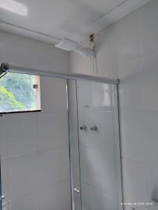 a shower with a glass door in a bathroom at Kitnetes Mobiliadas in Estancia do Castello +19 photos
