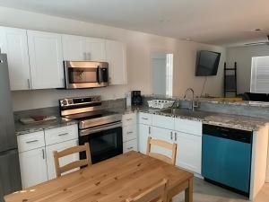 eine Küche mit weißen Schränken und einem Holztisch in der Unterkunft Water Oak lane in Canyon Lake