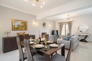 a dining room and living room with a table and chairs at Irene Luxury Villa in Metaxáta
