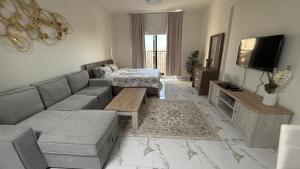 a living room with a couch and a tv at Studio - luxury, next to the beach in Ras al Khaimah