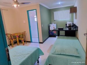 a room with two beds and a desk in it at Kitnetes Mobiliadas in Estancia do Castello