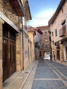 an alley in an old town with an archway at LA CASA DEL JAIME in Mora de Rubielos