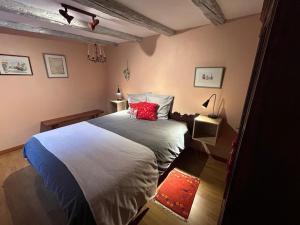 una camera da letto con un letto grande con cuscini rossi di Gite Gabrielle a Blaesheim