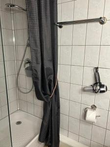 una doccia con tenda nera in bagno di Gite Gabrielle a Blaesheim