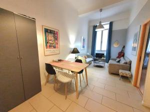 ニースにある3 rooms GEM in Old Town Niceのテーブルと椅子のあるキッチンとリビングルーム