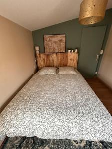 a bedroom with a bed with a wooden head board at Appartement F1 duplex Hyper centre in Saint-Dizier +5 photos