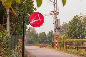 a red sign on a pole next to a road at Amigo Stay Noi Bai Airport in Sóc Sơn