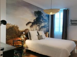 a bedroom with a white bed and a painting on the wall at 2 chambres 4pers à 13km Du Puy dufou in Saint-Amand-sur-Sèvre