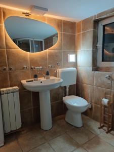 ein Badezimmer mit Waschbecken, Toilette und Spiegel in der Unterkunft Rustic central in Belgrad