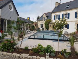 a house with a car parked in a driveway at La Ferme de Kérivoas in Audierne