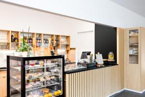 a store with a refrigerator filled with food at Hostel Sienkiewiczówka in Oblęgórek