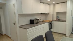 a kitchen with white cabinets and a microwave at FeWo-Seeheim Barrierefrei EG in Seeheim-Jugenheim