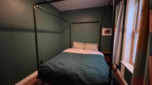 a four poster bed in a room with a window at Awesome Remodeled House in Denver