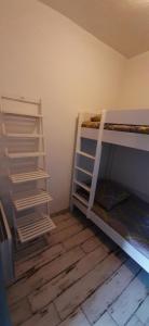 a room with two bunk beds in a room at Grand Appartement Luxe avec SAUNA et BAIN LED 50m de l océan avec belle terrasse pour manger CHIEN ADMIS 2 chambres pour 4 pers avec GRANDE BAIGNOIRE BALNEO SPA in Biscarrosse