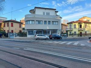 dwa samochody zaparkowane przed budynkiem na ulicy w obiekcie Marconi House w Mestre
