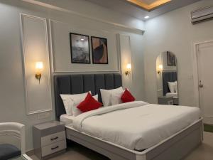a bedroom with a large white bed with red pillows at JD Heritage Inn in Bareilly +9 photos