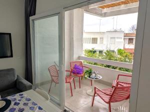 a room with a balcony with chairs and a table at Delizioso appartamento vicino al mare di Lecce in San Cataldo