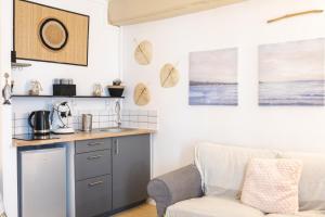 a kitchen with a chair next to a counter at La Villa Au petit bonheur in Honfleur +40 photos