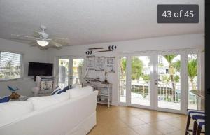 a living room with a white couch and sliding glass doors at Paridise luxury & fishing canal Home in Tavernier
