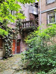 an old building with a balcony on the side of it at Appartement calme hypercentre in Clermont-Ferrand