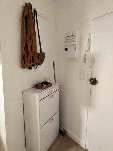 a kitchen with a refrigerator and a bag on the wall at Appartement calme hypercentre in Clermont-Ferrand +1 photo
