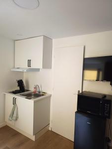 a small kitchen with a sink and a microwave at Appartement calme hypercentre in Clermont-Ferrand