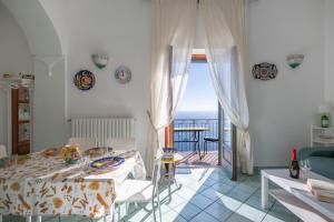 Un comedor con mesa y vista al mar. en CASA RITALEMMA', en Amalfi