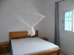 a bedroom with a bed with a net on it at Lagune Teranga in Somone