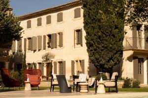 a group of chairs and tables in front of a building at La Maison - Grignan in Grignan