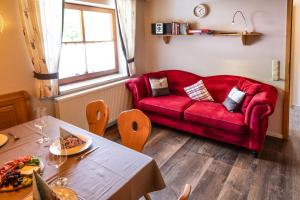 a living room with a red couch and a table at Ferienlandhaus Brunner in Zachenberg