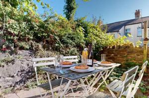 a table with plates of food and bottles of wine at Cardiff City Two Bedroom Home in Cardiff