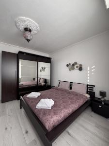 a bedroom with a large bed with two towels on it at Appartement des 3 pays. 2 mn de Bâle+ Free parking in Saint-Louis