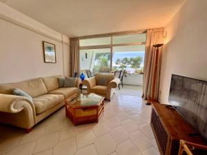 a living room with a couch and a table at MIRAFLORES BEACH&TENNIS AMAZING VIEW BY THE SEA in Sitio de Calahonda